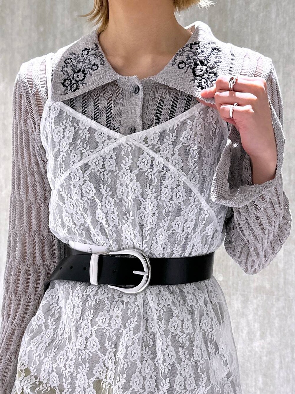 イエロー系のカーゴパンツ、グレー系のニット/セーター、ホワイト系のワンピースを着用したレディースの春コーディネートの6枚目の写真