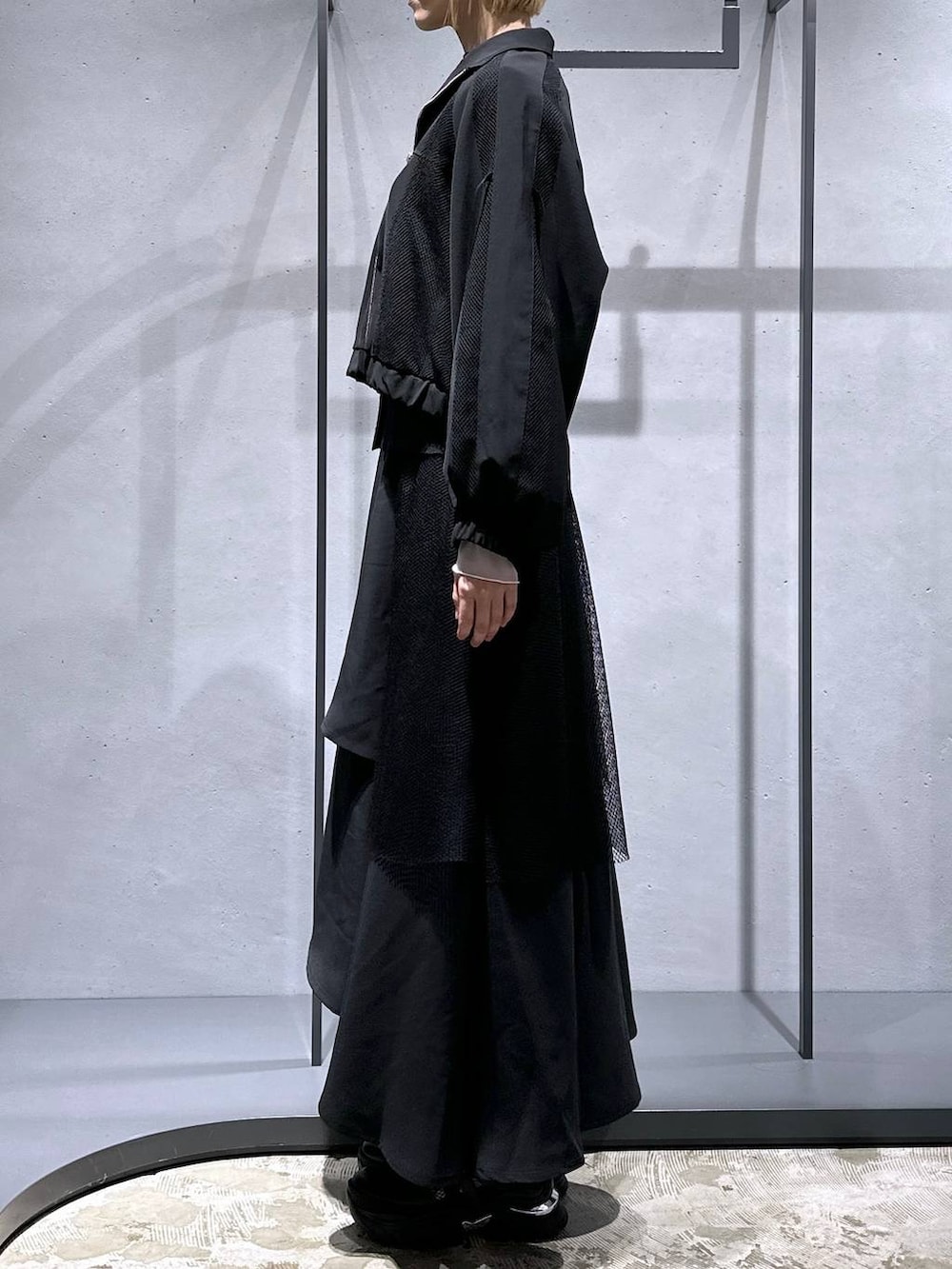 グリーン系のカーディガン/ボレロ、ブラック系のTシャツ/カットソー、ブラック系のスニーカーを着用したレディースの冬コーディネートの2枚目の写真