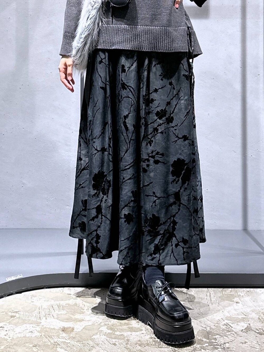 ブルー系のTシャツ/カットソー、グレー系のニット/セーター、グレー系のショルダーバッグを着用したレディースの秋コーディネートの6枚目の写真