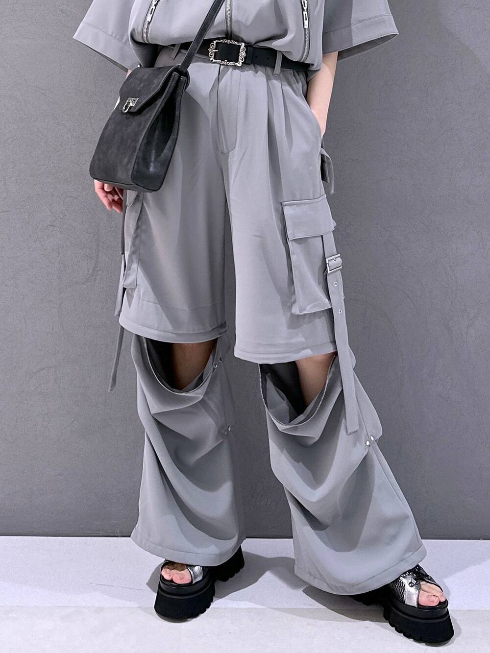 シルバー系のサンダル、グレー系のカーゴパンツ、グレー系のブルゾンを着用したレディースの春コーディネートの6枚目の写真