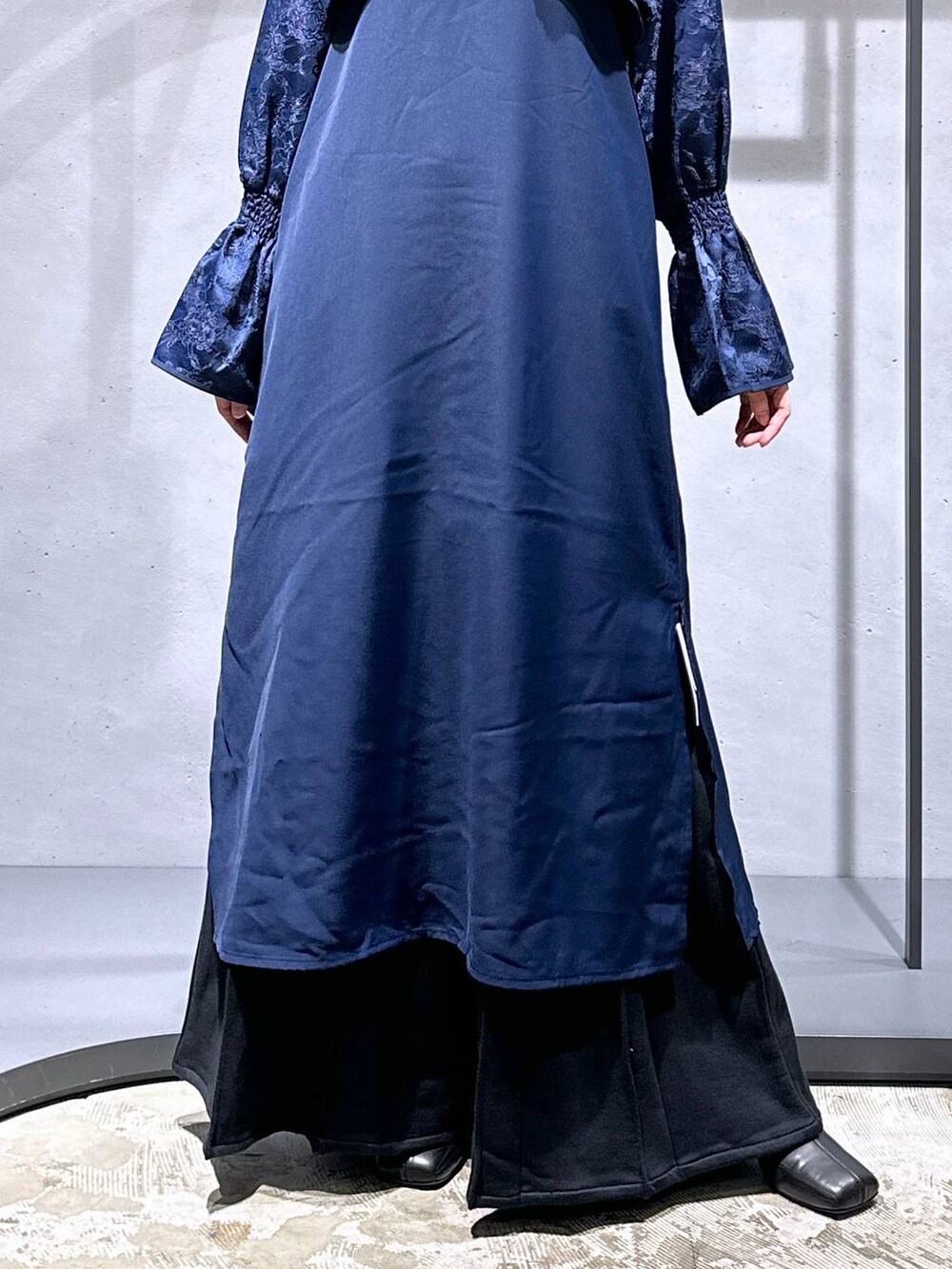 ブラック系のブーツ、ブラック系のスウェットパンツ、ブルー系のワンピースを着用したレディースの秋コーディネートの6枚目の写真