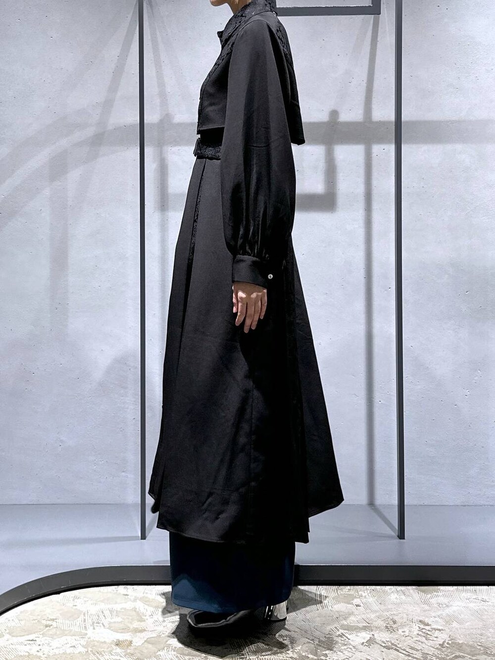 シルバー系のブーツ、ブルー系のその他パンツ、ブラック系のワンピースを着用したレディースの秋コーディネートの2枚目の写真