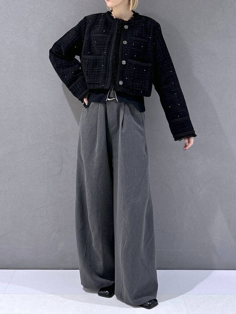 ブラック系のカーディガン/ボレロ、ブラック系のブーツ、グレー系のスラックスを着用したレディースの秋コーディネートの4枚目の写真