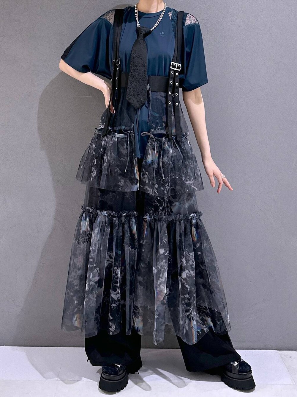 ブラック系のネクタイ、ブラック系のサンダル、グレー系のスカートを着用したレディースの春コーディネートの4枚目の写真