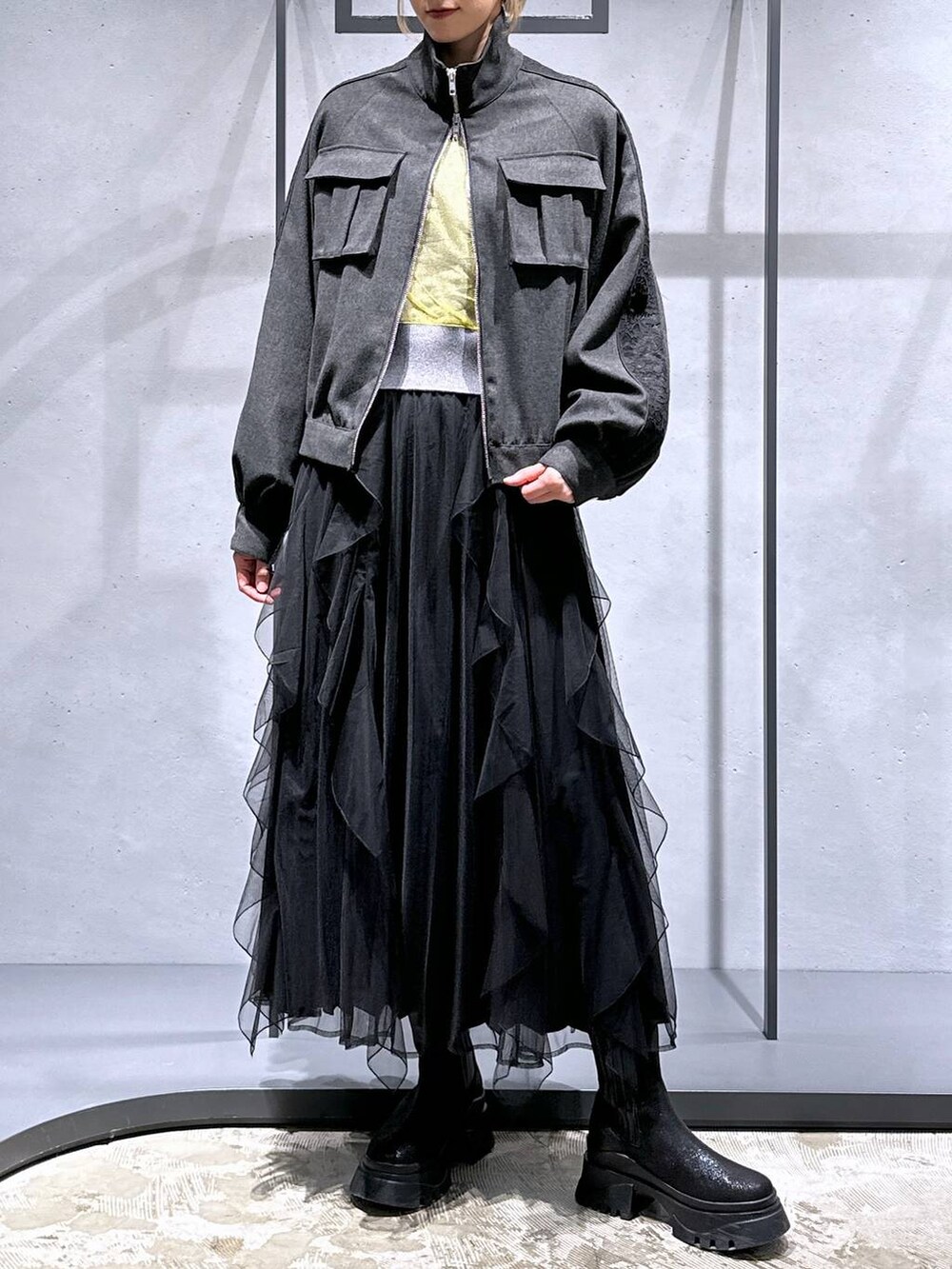 ブラック系のブーツ、イエロー系のカーディガン/ボレロ、グレー系のブルゾンを着用したレディースの冬コーディネートの4枚目の写真