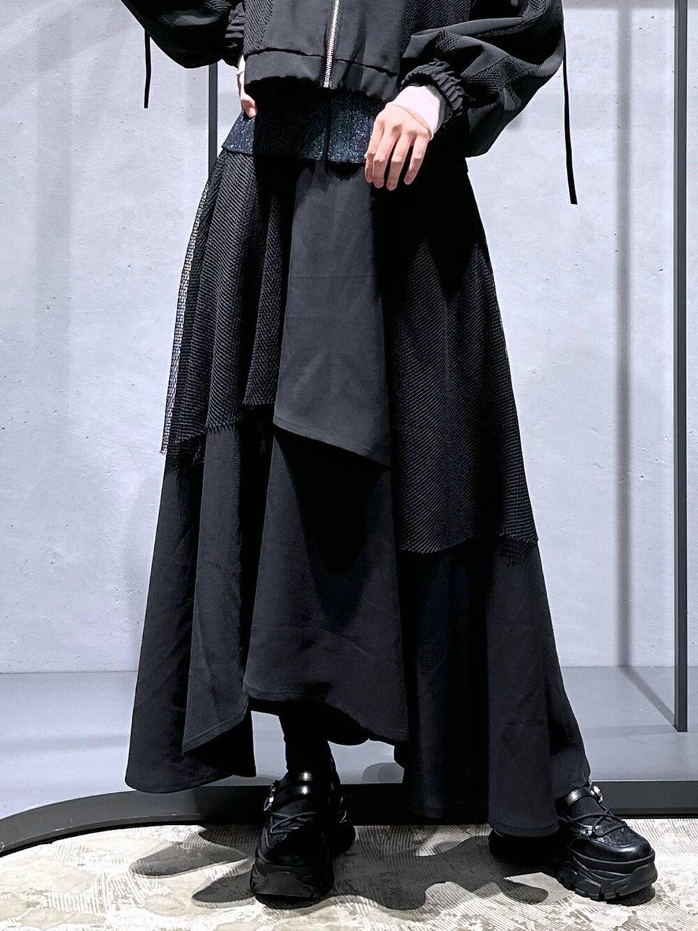 グリーン系のカーディガン/ボレロ、ブラック系のTシャツ/カットソー、ブラック系のスニーカーを着用したレディースの冬コーディネートの6枚目の写真