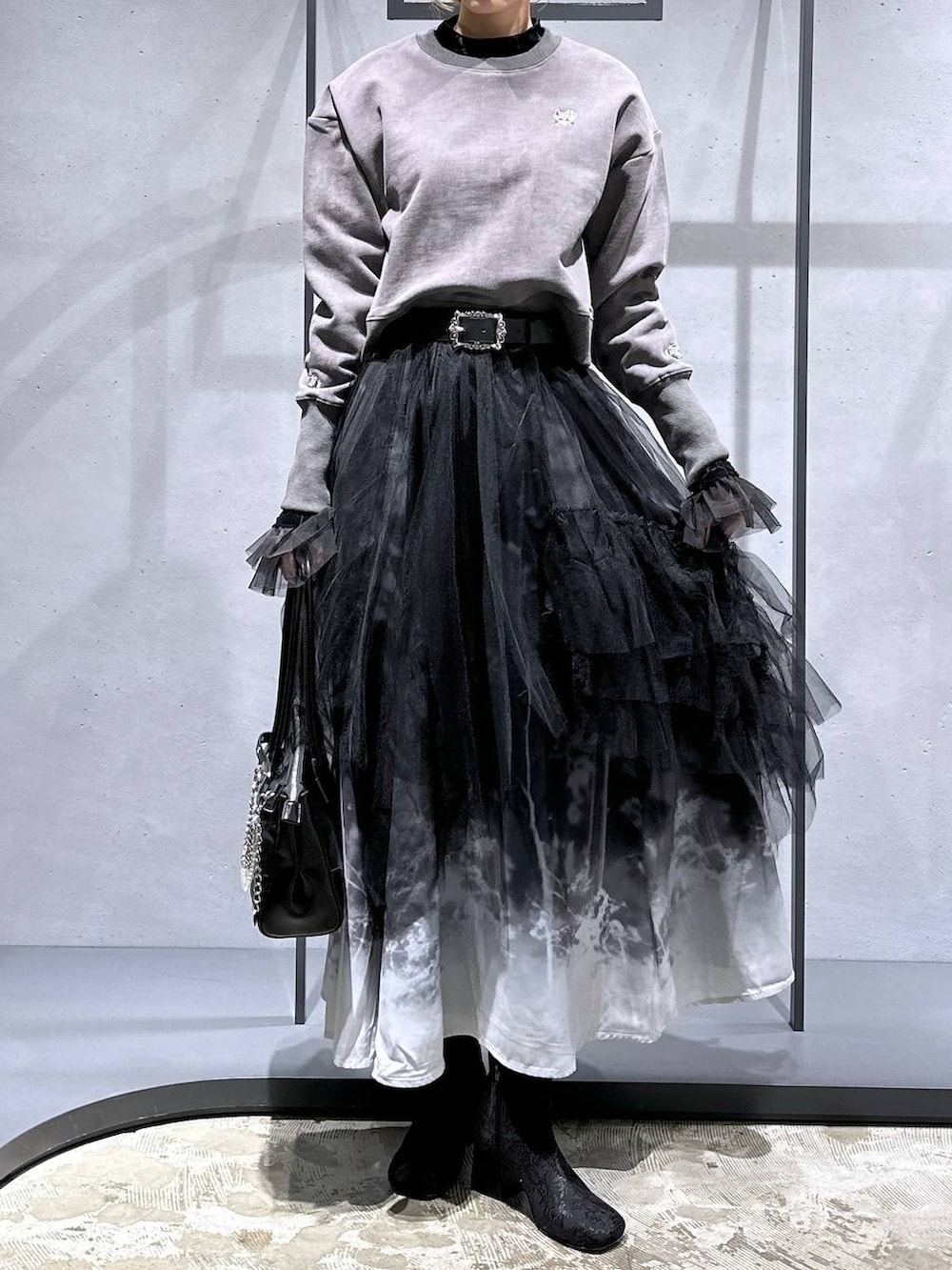 ブラック系のTシャツ/カットソー、ブラック系のブーツ、ブラック系のスウェットを着用したレディースの冬コーディネートの4枚目の写真