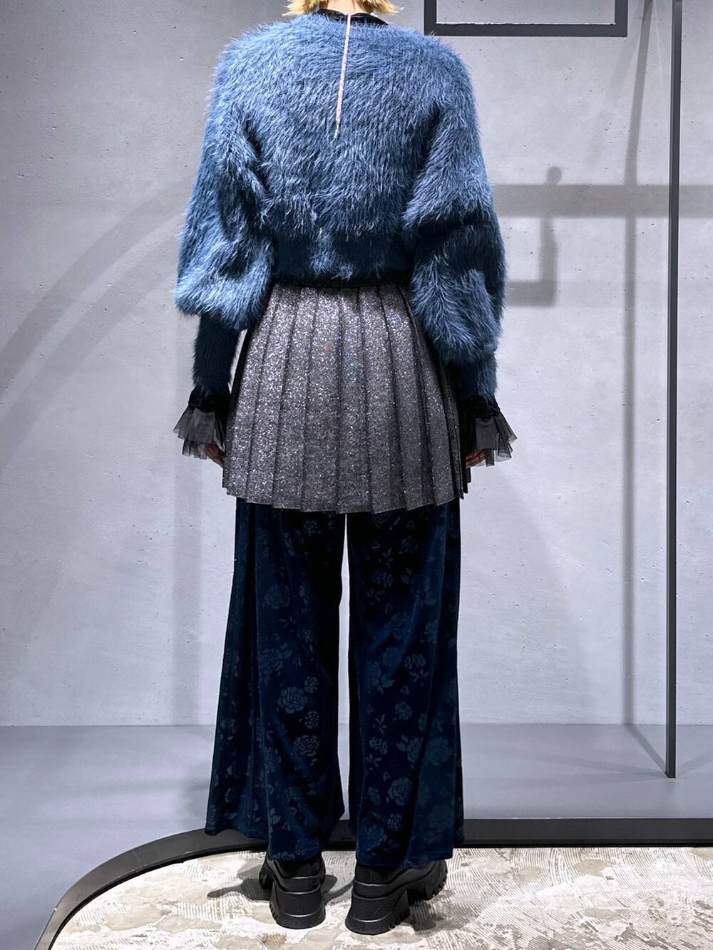 ブラック系のネクタイ、ブルー系のニット/セーター、ブラック系のTシャツ/カットソーを着用したレディースの冬コーディネートの3枚目の写真