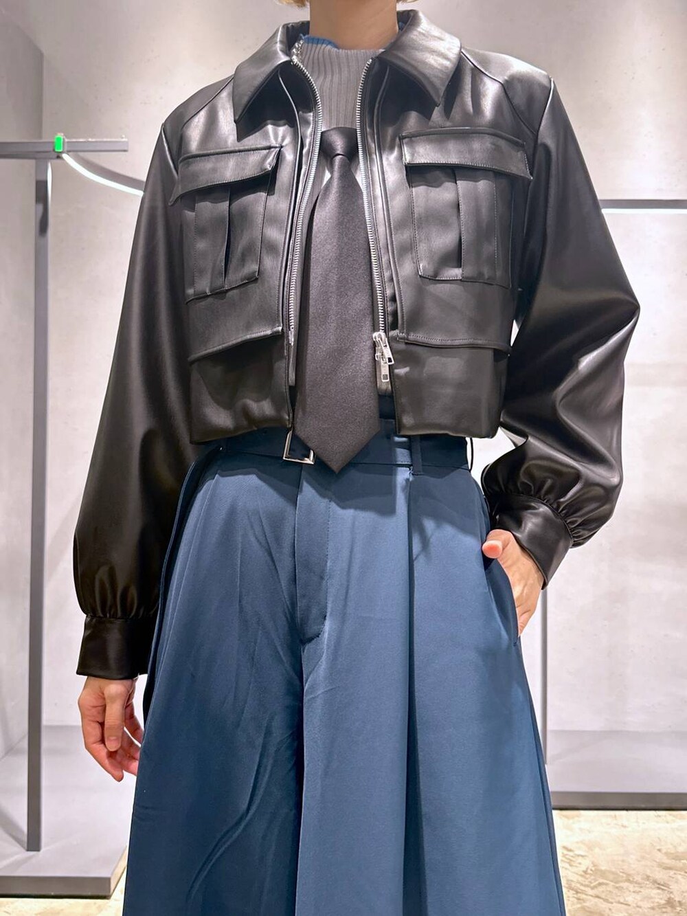 ブラック系のネクタイ、ブラック系のブーツ、グレー系のニット/セーターを着用したレディースの秋コーディネートの5枚目の写真