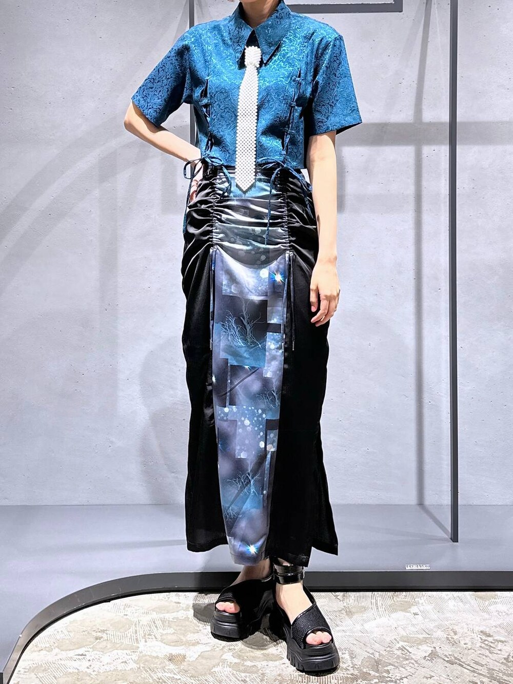 グリーン系のシャツ/ブラウス、ブラック系のサンダル、ブラック系のスカートを着用したレディースの夏コーディネートの6枚目の写真