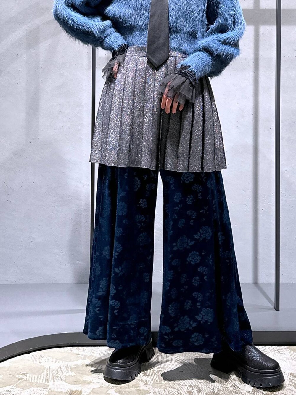 ブラック系のネクタイ、ブルー系のニット/セーター、ブラック系のTシャツ/カットソーを着用したレディースの冬コーディネートの7枚目の写真