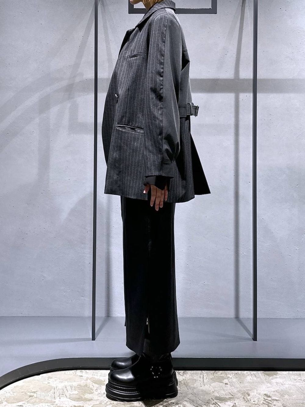 ブラック系のブーツ、グレー系のテーラードジャケット、ブラック系のシャツ/ブラウスを着用したレディースの冬コーディネートの2枚目の写真