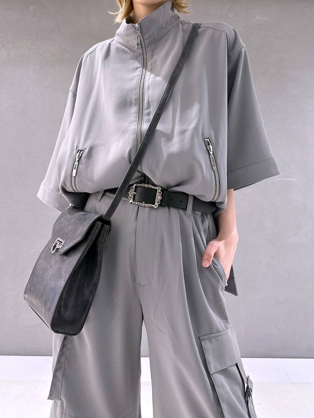 シルバー系のサンダル、グレー系のカーゴパンツ、グレー系のブルゾンを着用したレディースの春コーディネートの5枚目の写真