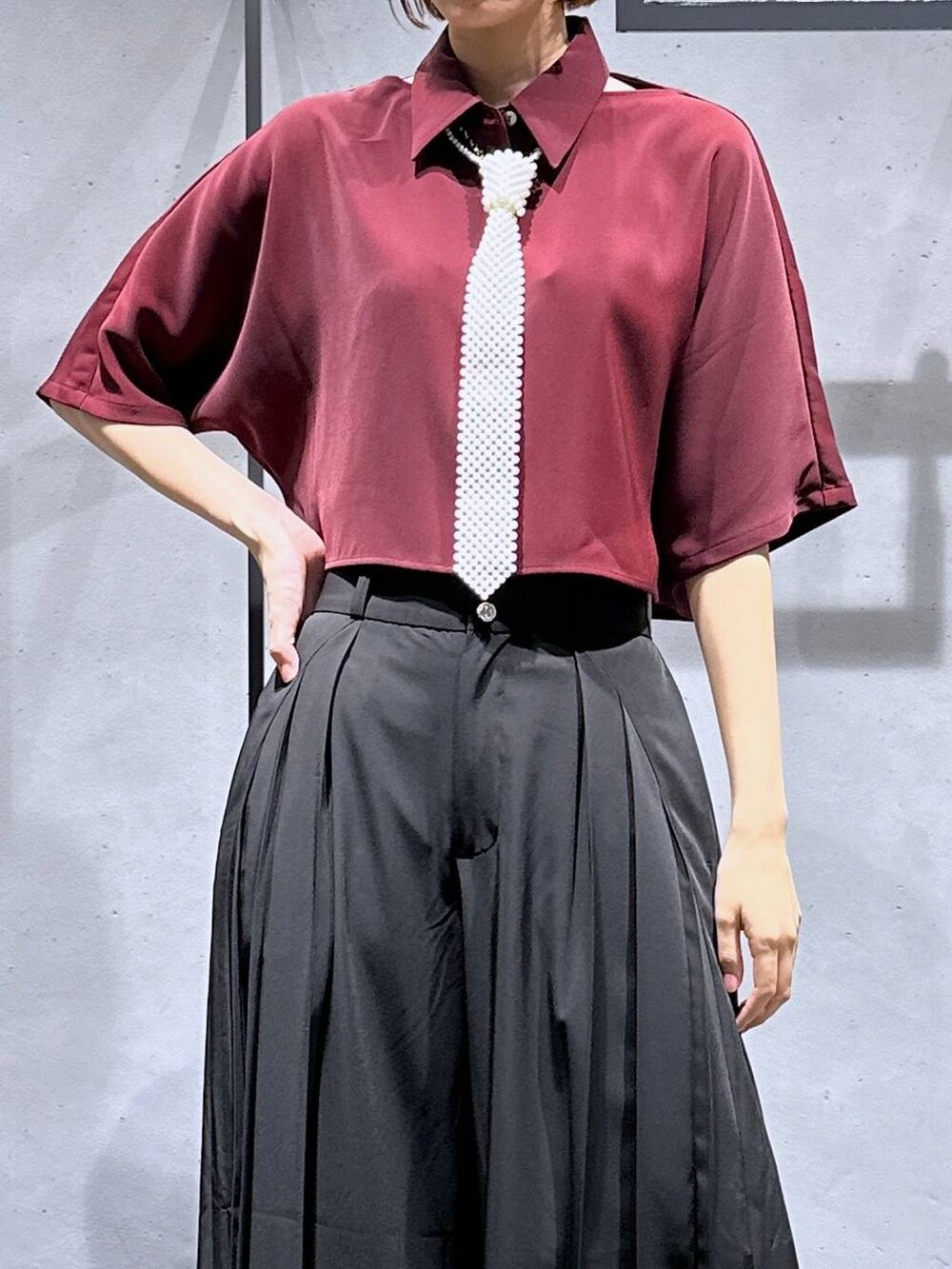 ブラック系のサンダル、ブラック系のその他パンツ、レッド系のシャツ/ブラウスを着用したレディースの夏コーディネートの6枚目の写真