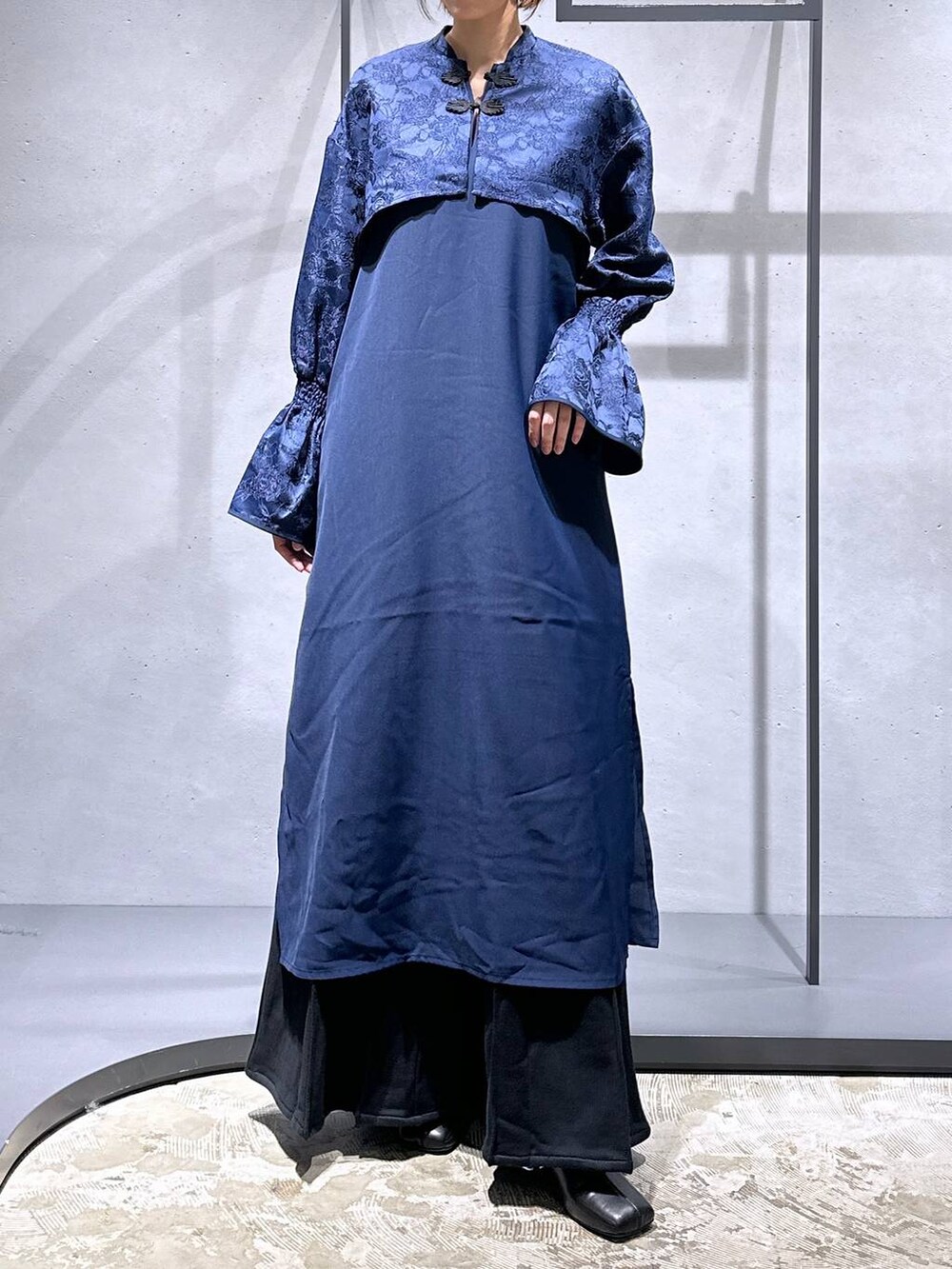 ブラック系のブーツ、ブラック系のスウェットパンツ、ブルー系のワンピースを着用したレディースの秋コーディネートの4枚目の写真