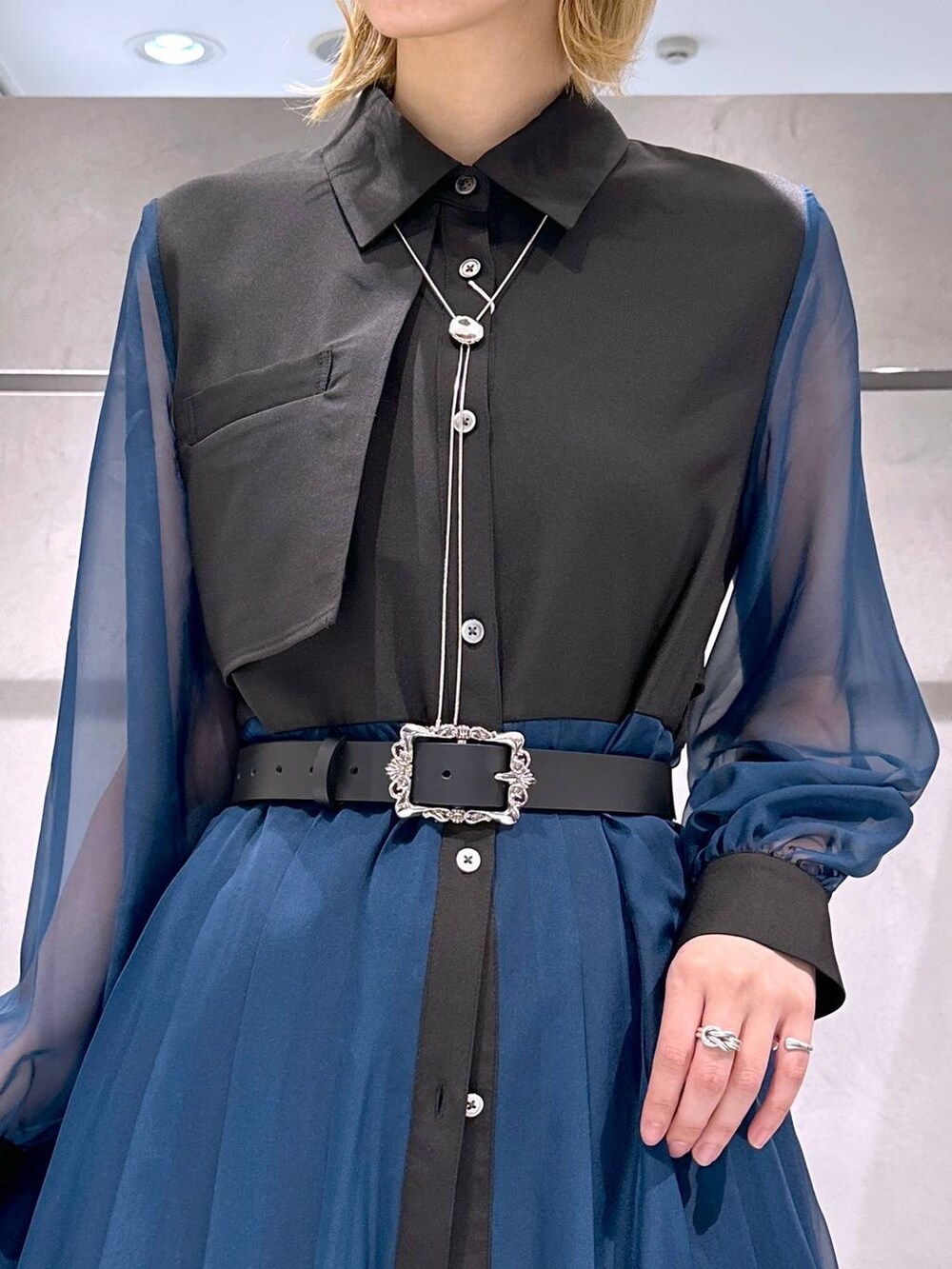 シルバー系のサンダル、ブラック系のワンピース、ホワイト系のスラックスを着用したレディースの春コーディネートの6枚目の写真