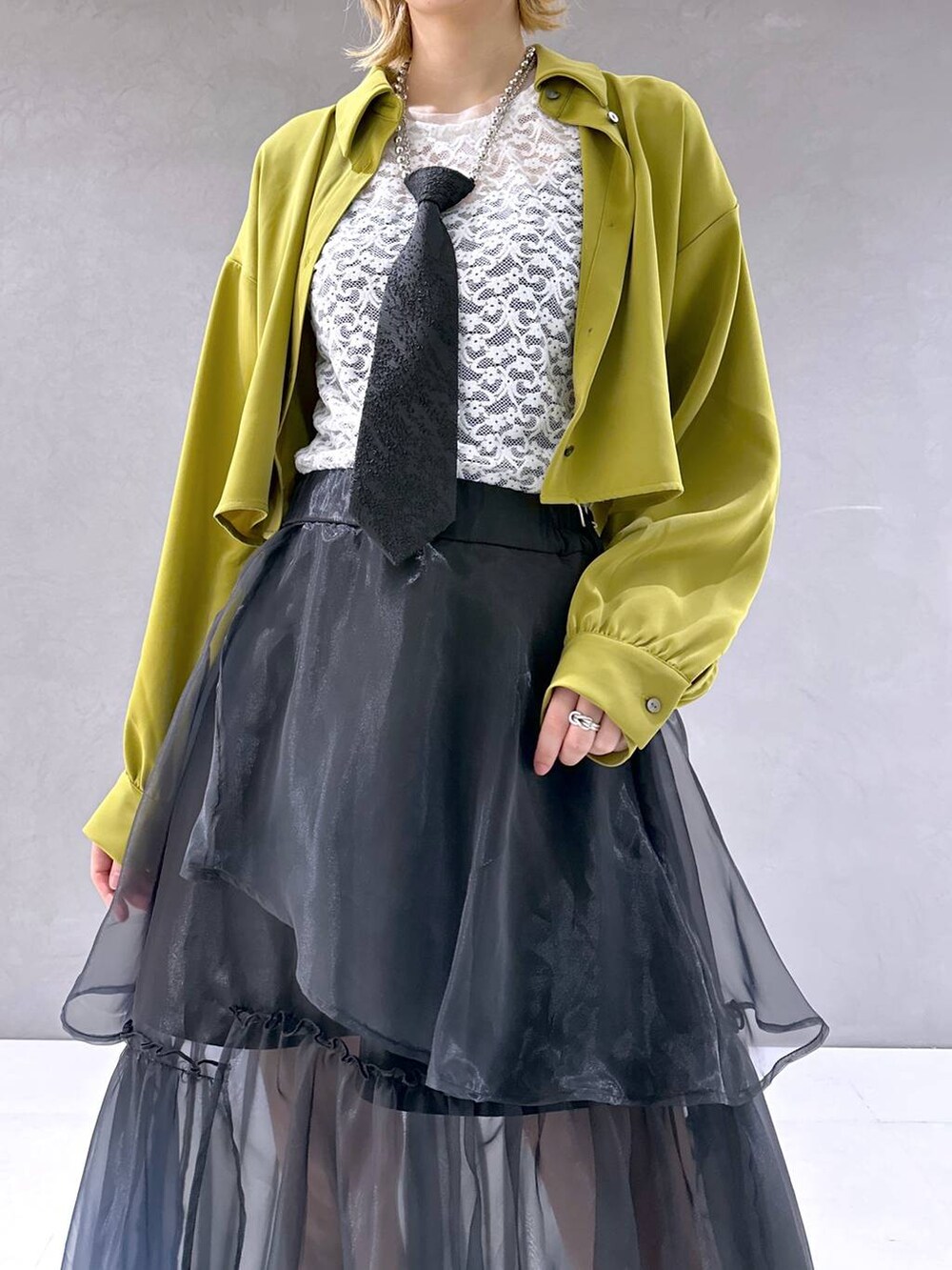 ブラック系のネクタイ、シルバー系のサンダル、イエロー系のシャツ/ブラウスを着用したレディースの春コーディネートの5枚目の写真