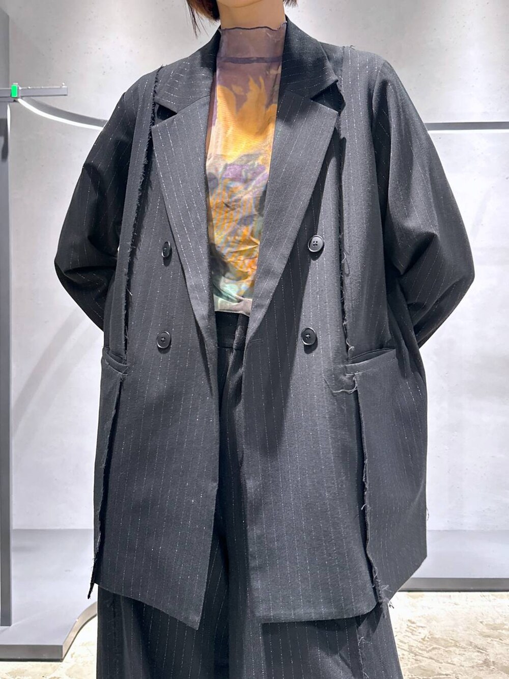 パープル系のTシャツ/カットソー、ブラック系のブーツ、ブラック系のテーラードジャケットを着用したレディースの秋コーディネートの5枚目の写真