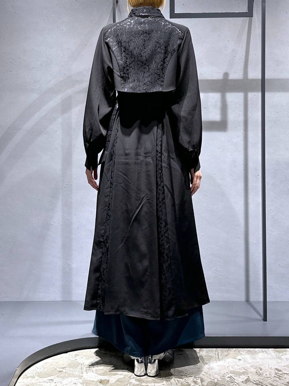 シルバー系のブーツ、ブルー系のその他パンツ、ブラック系のワンピースを着用したレディースの秋コーディネートの3枚目の写真