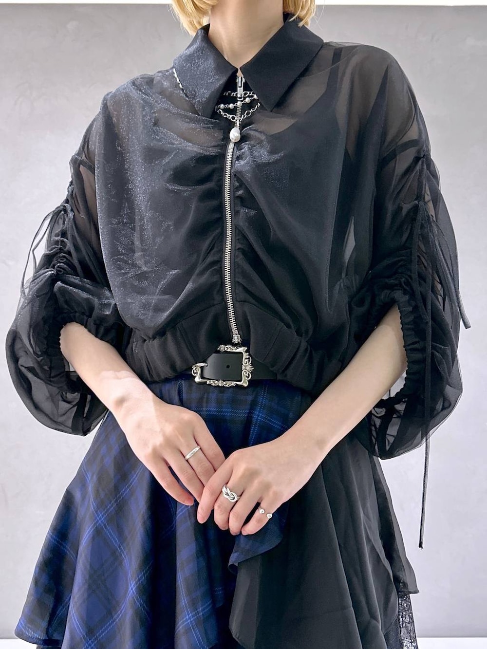 ブラック系のサンダル、ブルー系のスカート、ブラック系のブルゾンを着用したレディースの夏コーディネートの5枚目の写真