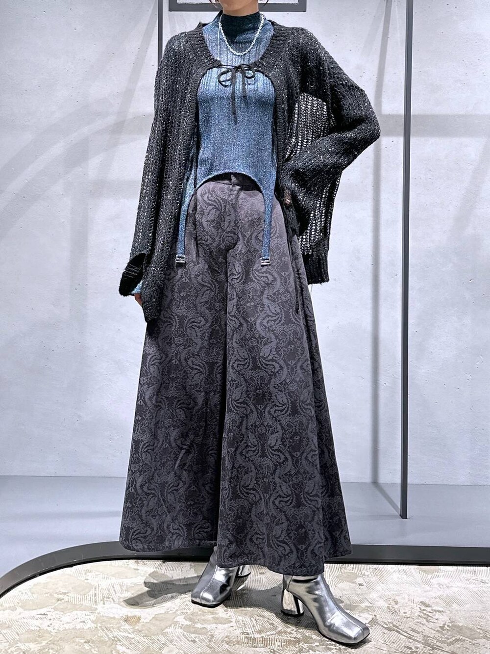 ブラック系のニット/セーター、シルバー系のブーツ、ブルー系のニット/セーターを着用したレディースの秋コーディネートの4枚目の写真