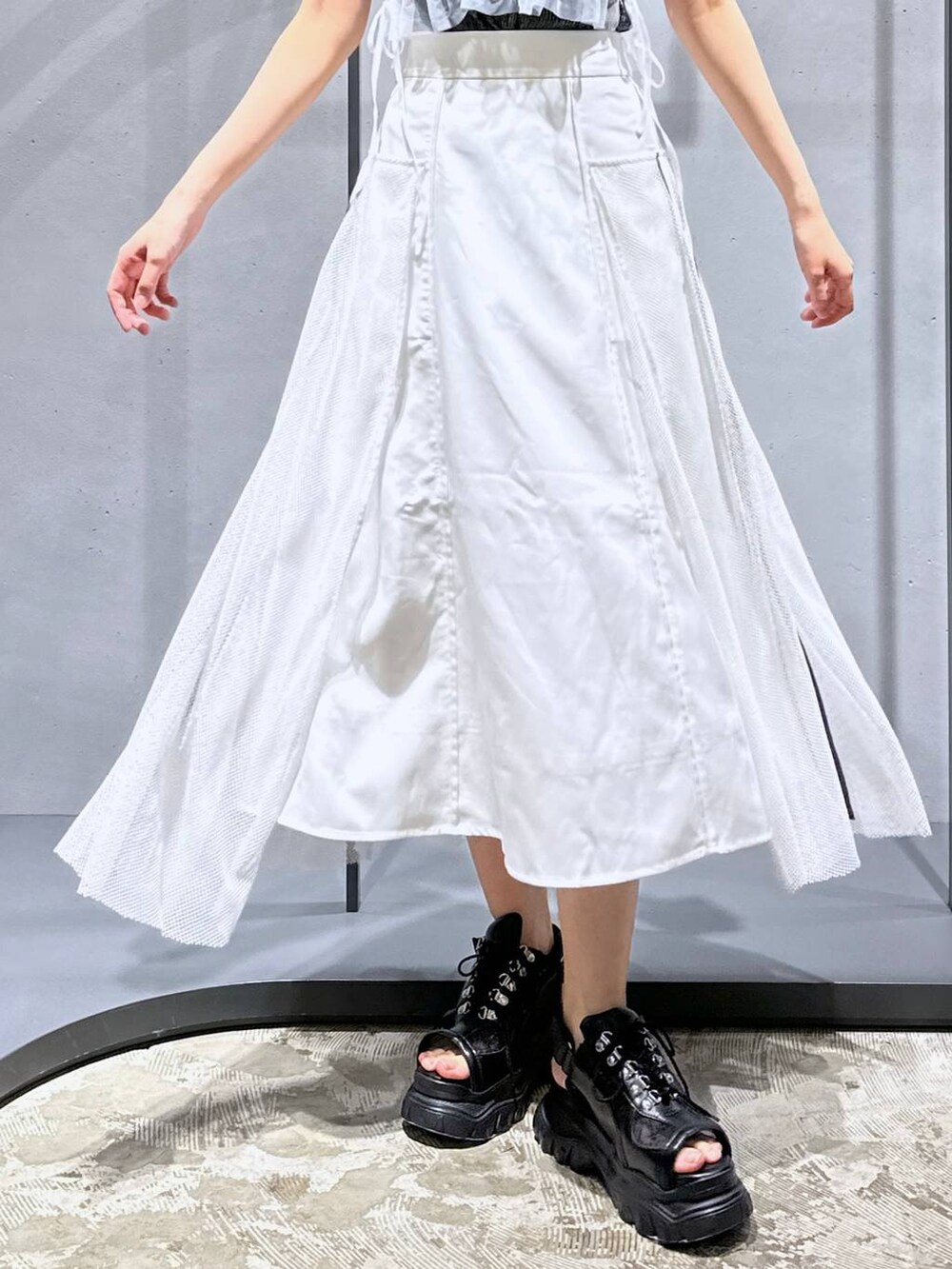 シルバー系のチューブトップ、ブラック系のTシャツ/カットソー、ホワイト系のスカートを着用したレディースの夏コーディネートの7枚目の写真