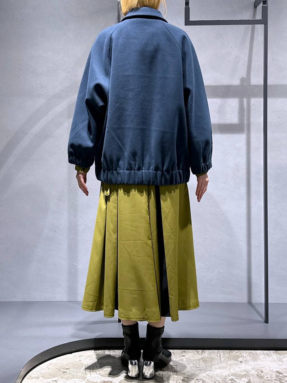 ブラック系のブーツ、ブルー系のブルゾン、イエロー系のワンピースを着用したレディースの冬コーディネートの3枚目の写真