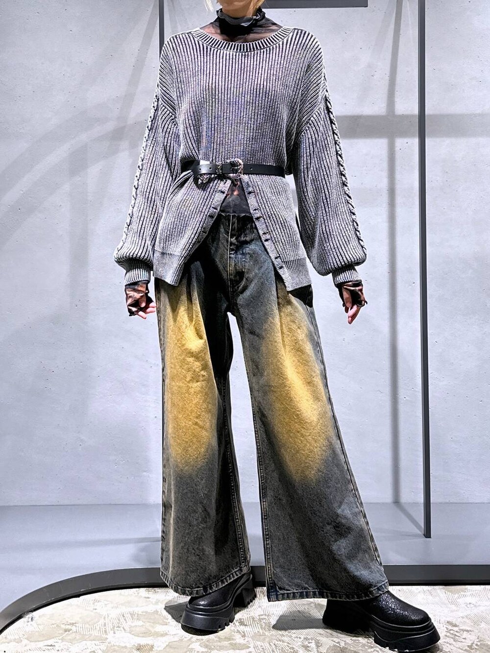 オレンジ系のデニムパンツ、ブラック系のブーツ、オレンジ系のTシャツ/カットソーを着用したレディースの秋コーディネートの4枚目の写真