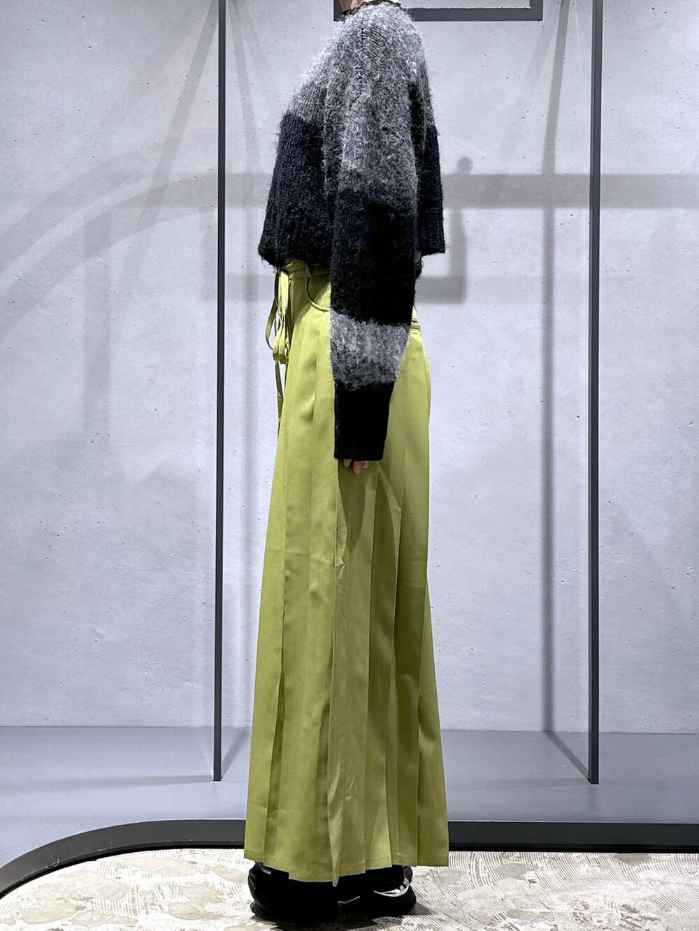 ブラック系のニット/セーター、グリーン系のその他パンツ、ブラック系のスニーカーを着用したレディースの冬コーディネートの2枚目の写真