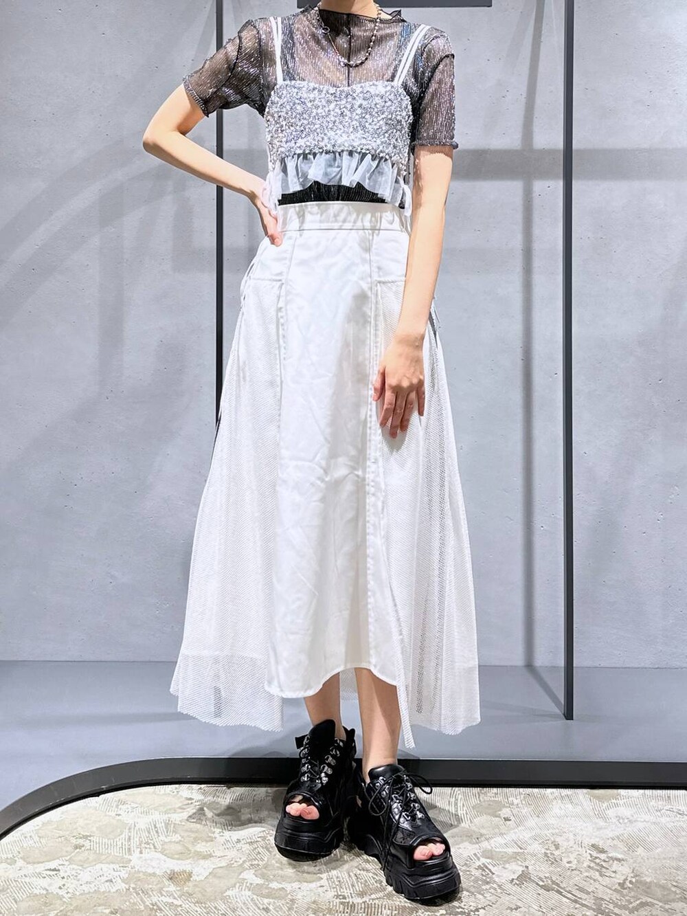 シルバー系のチューブトップ、ブラック系のTシャツ/カットソー、ホワイト系のスカートを着用したレディースの夏コーディネートの4枚目の写真