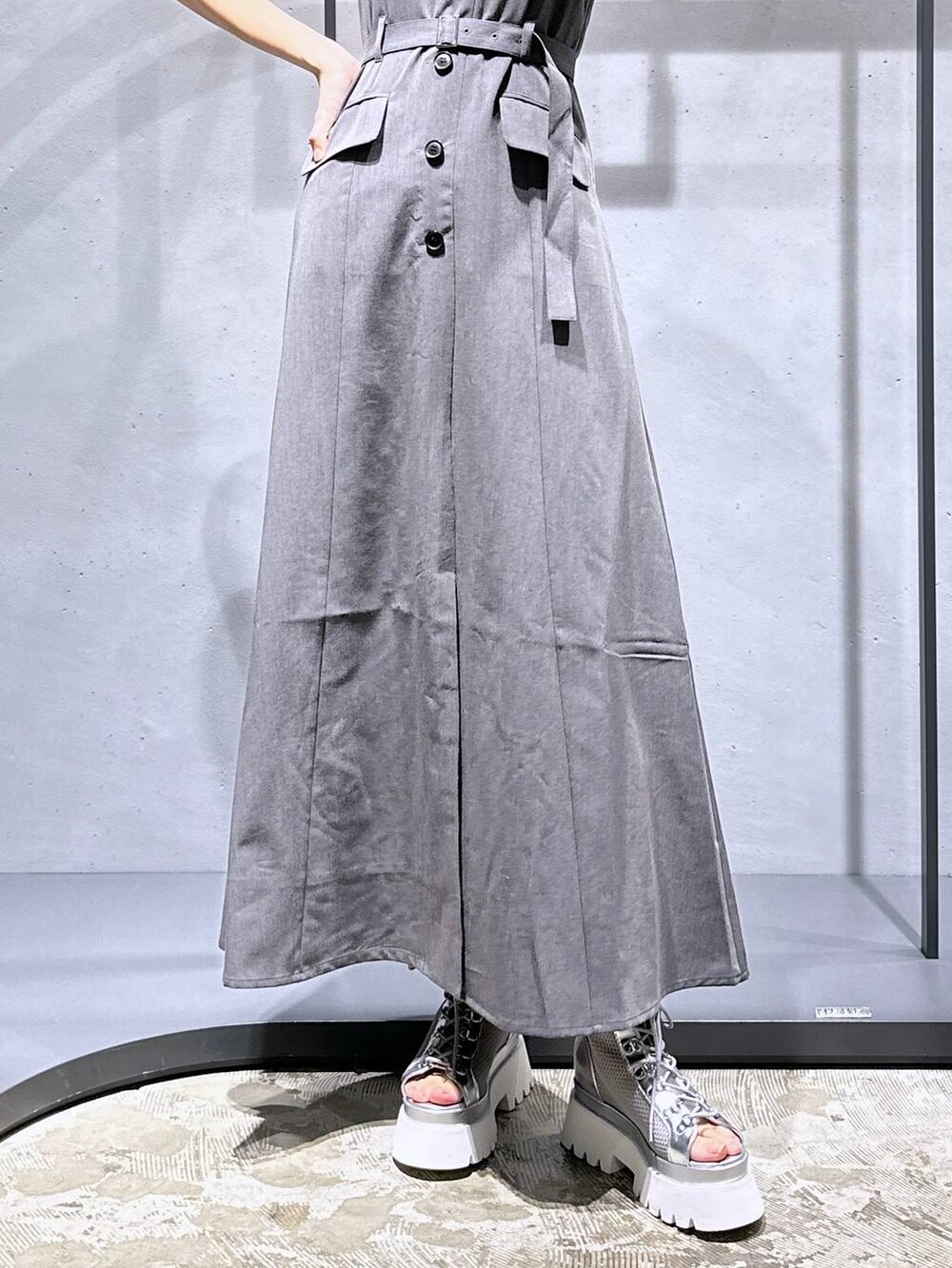 シルバー系のサンダル、オレンジ系のTシャツ/カットソー、グレー系のジャンパースカートを着用したレディースの夏コーディネートの8枚目の写真