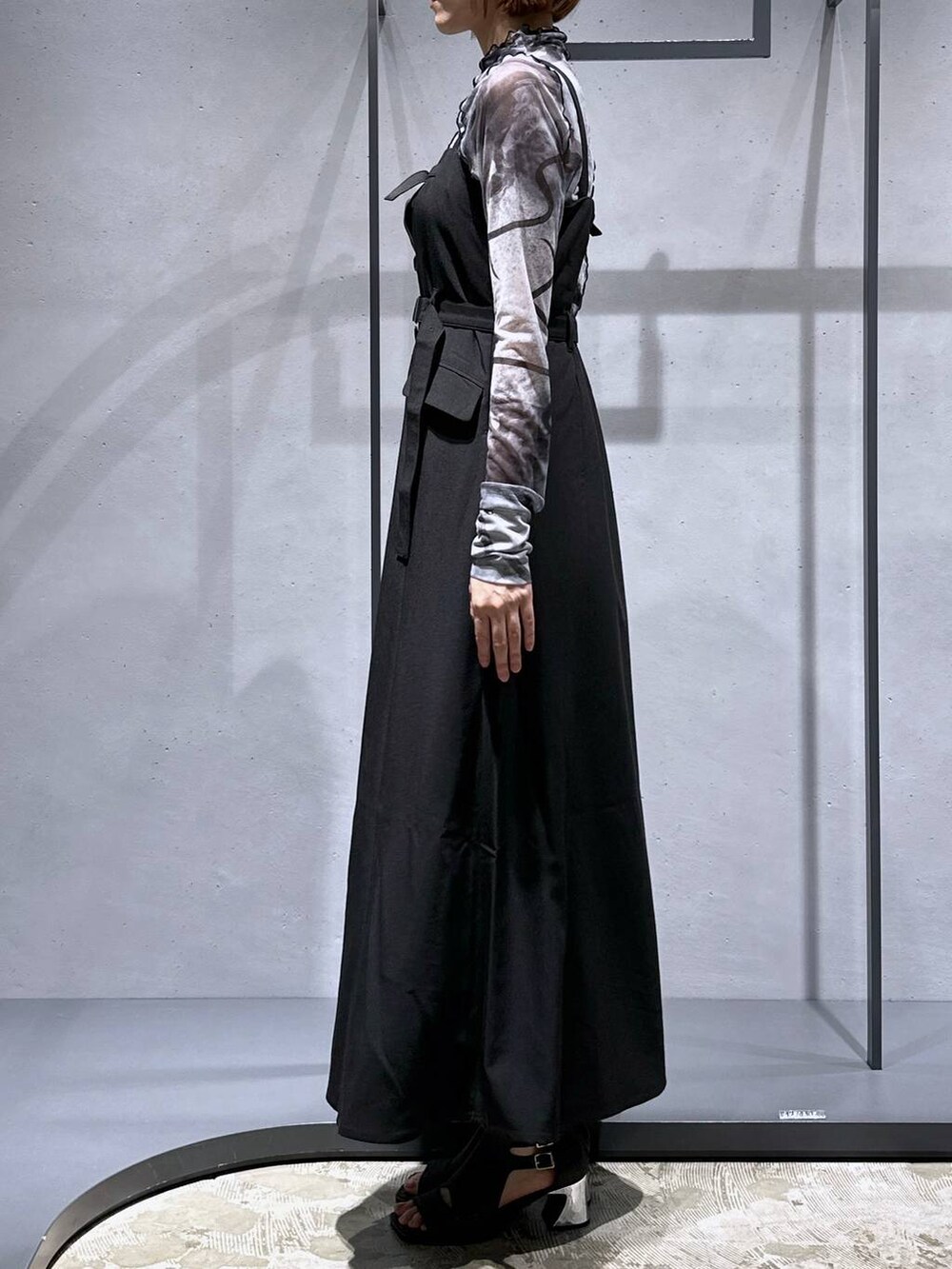 ブラック系のサンダル、ブラック系のジャンパースカート、ホワイト系のTシャツ/カットソーを着用したレディースの夏コーディネートの5枚目の写真