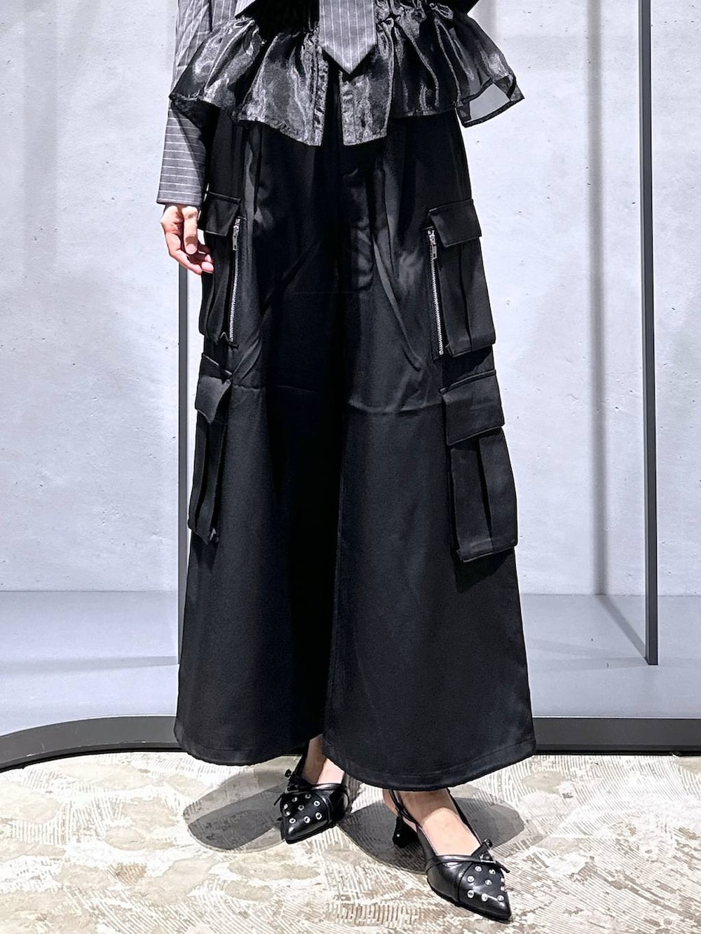 ブラック系のパンプス、ブラック系のベスト、ブラック系のカーゴパンツを着用したレディースの夏コーディネートの6枚目の写真