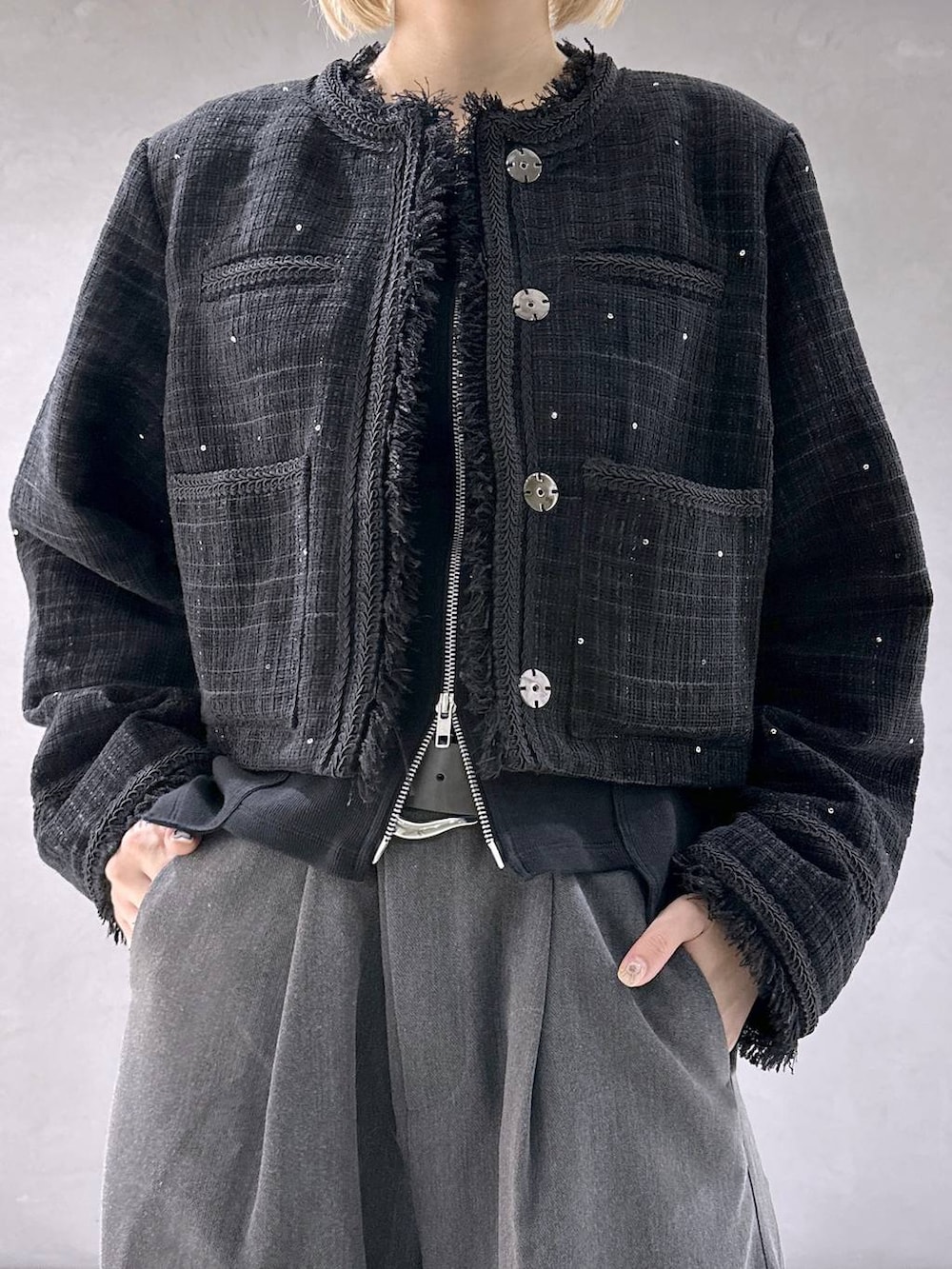 ブラック系のカーディガン/ボレロ、ブラック系のブーツ、グレー系のスラックスを着用したレディースの秋コーディネートの5枚目の写真