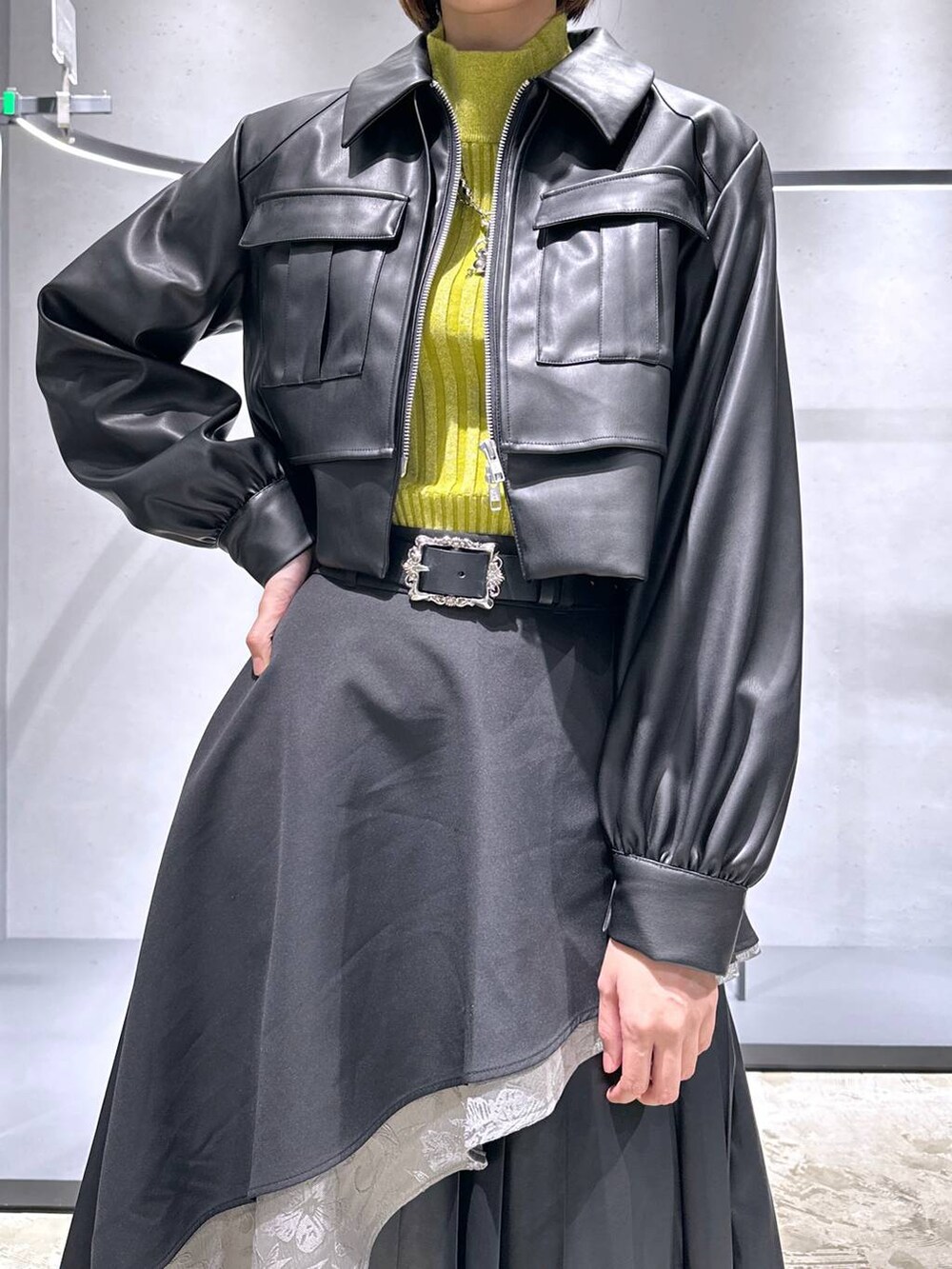 グレー系のスカート、イエロー系のニット/セーター、ブラック系のブーツを着用したレディースの秋コーディネートの5枚目の写真