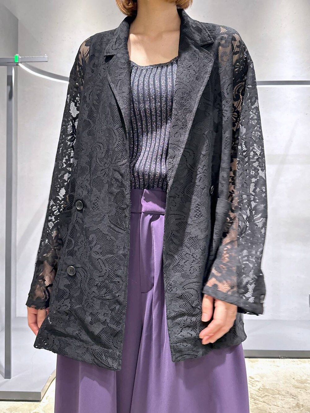 ブラック系のタンクトップ、パープル系のスラックス、ブラック系のブーツを着用したレディースの夏コーディネートの5枚目の写真