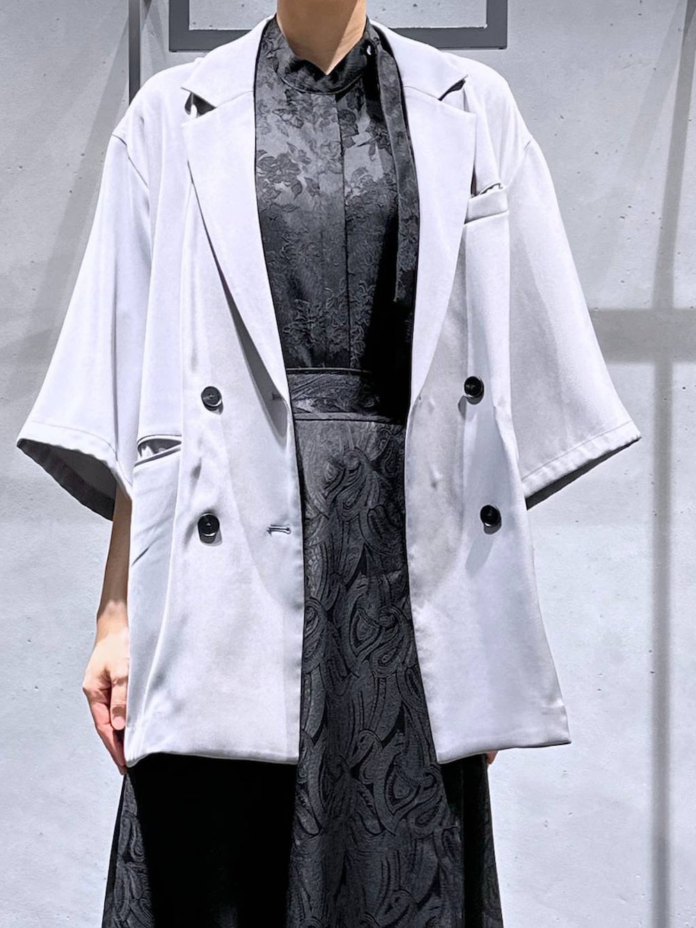 ブラック系のサンダル、ブラック系のスカート、グレー系のテーラードジャケットを着用したレディースの春コーディネートの5枚目の写真