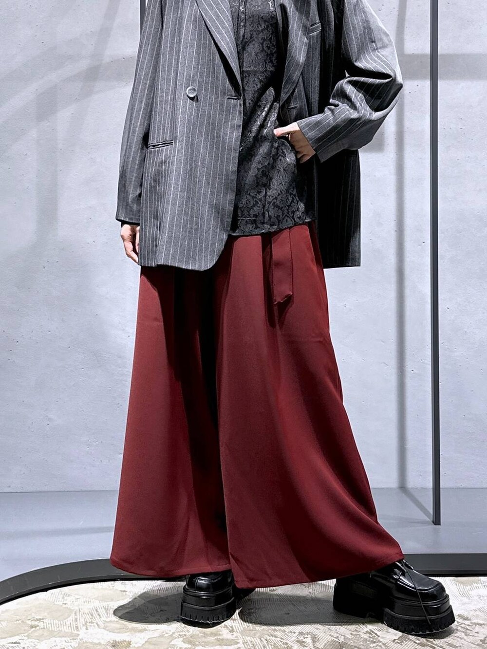 レッド系のその他パンツ、ブラック系のシャツ/ブラウス、ブラック系のドレスシューズを着用したレディースの秋コーディネートの6枚目の写真