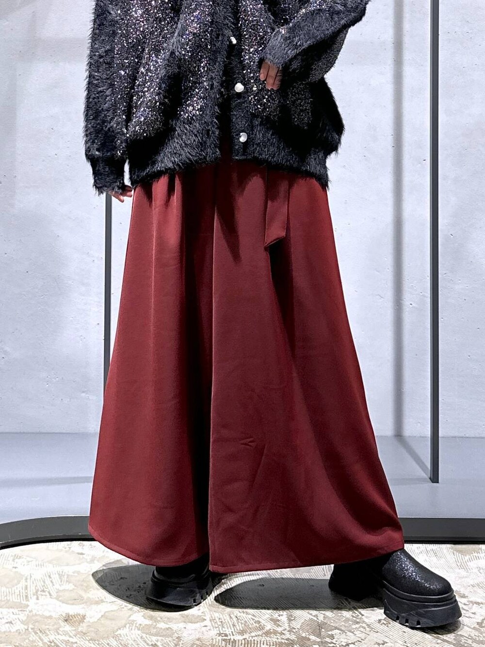 レッド系のその他パンツ、ブラック系のブーツ、ブラック系のニット/セーターを着用したレディースの冬コーディネートの6枚目の写真