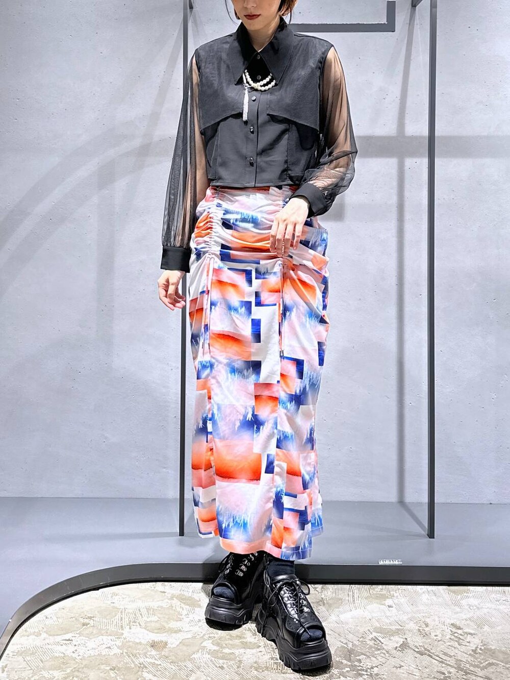 ホワイト系のスカート、ブラック系のサンダル、ブラック系のシャツ/ブラウスを着用したレディースの夏コーディネートの4枚目の写真