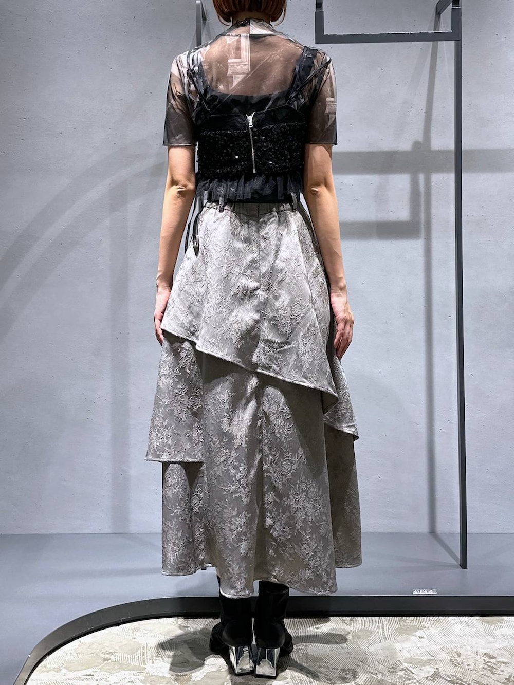 ブラック系のサンダル、ブラック系のチューブトップ、グレー系のスカートを着用したレディースの夏コーディネートの4枚目の写真