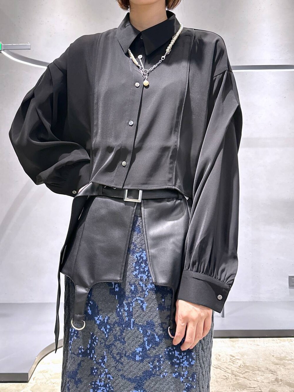 グレー系のスカート、ブラック系のブーツ、ブラック系のシャツ/ブラウスを着用したレディースの秋コーディネートの5枚目の写真