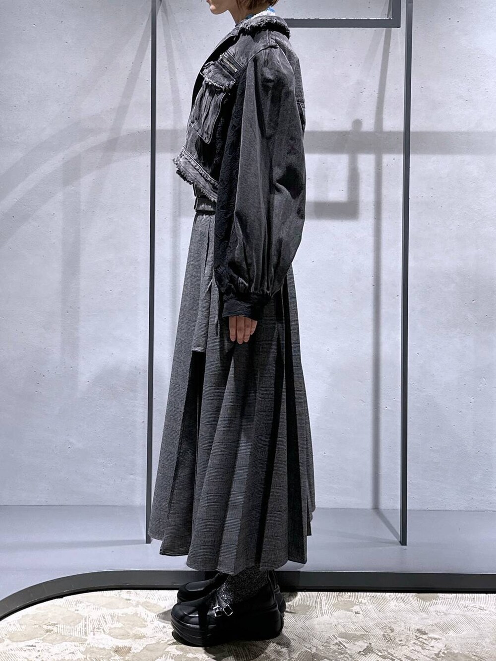 ブラック系のショルダーバッグ、シルバー系のブーツ、グレー系のニット/セーターを着用したレディースの秋コーディネートの2枚目の写真