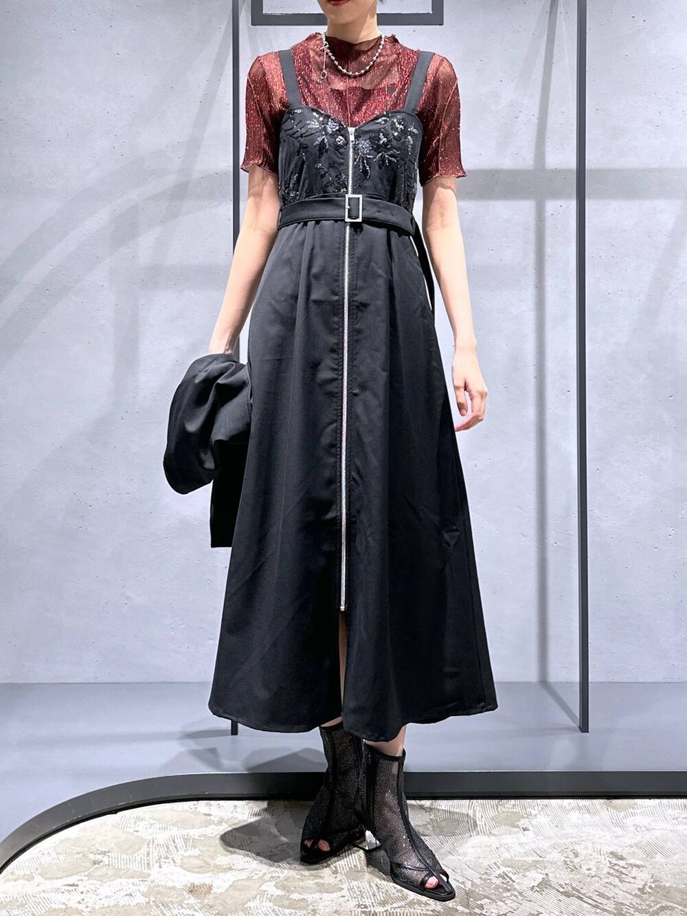 ブラック系のサンダル、レッド系のTシャツ/カットソー、ブラック系のジャンパースカートを着用したレディースの夏コーディネートの4枚目の写真