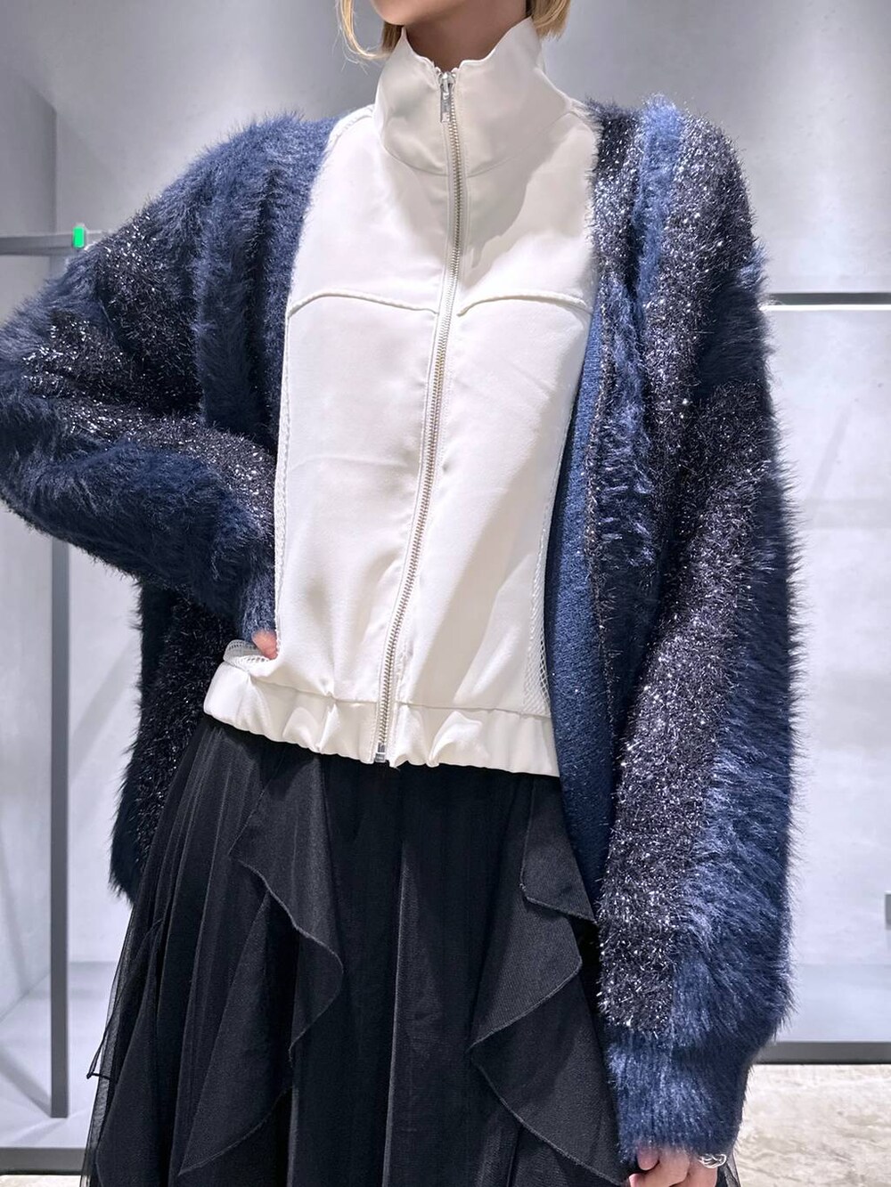 ブルー系のカーディガン/ボレロ、ブラック系のスニーカー、ブラック系のスカートを着用したレディースの冬コーディネートの5枚目の写真