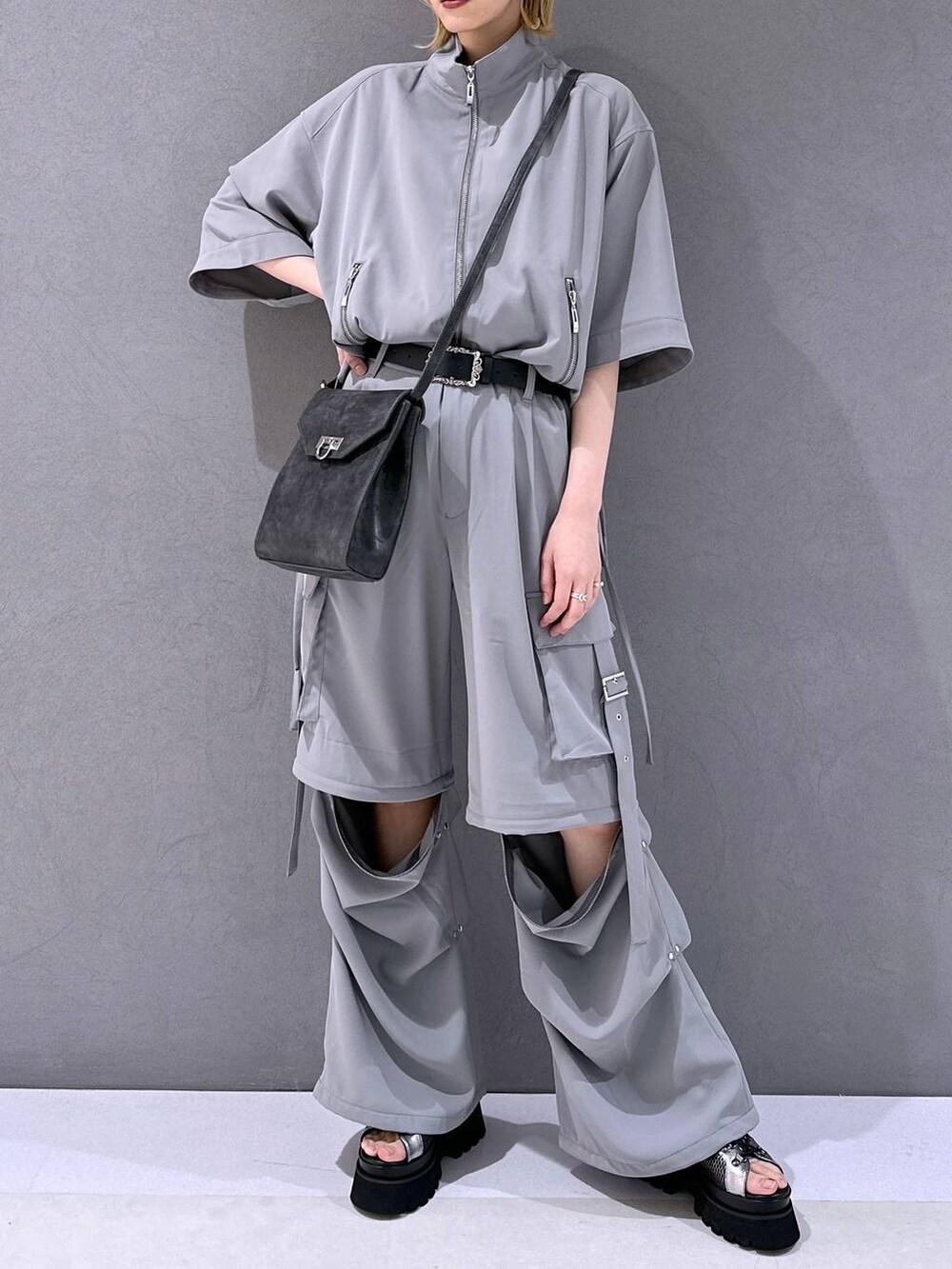 シルバー系のサンダル、グレー系のカーゴパンツ、グレー系のブルゾンを着用したレディースの春コーディネートの4枚目の写真