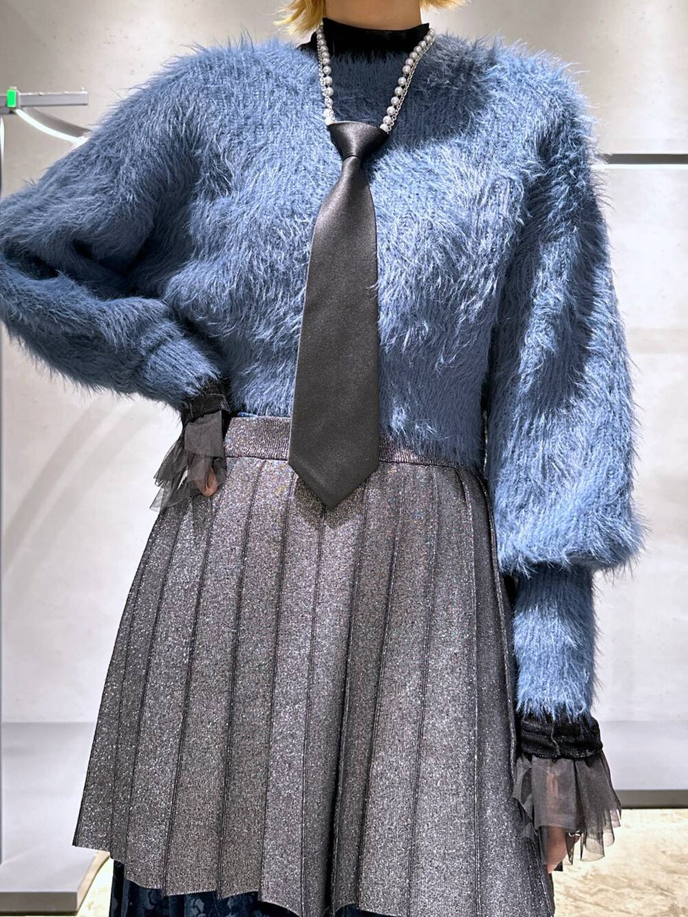 ブラック系のネクタイ、ブルー系のニット/セーター、ブラック系のTシャツ/カットソーを着用したレディースの冬コーディネートの6枚目の写真