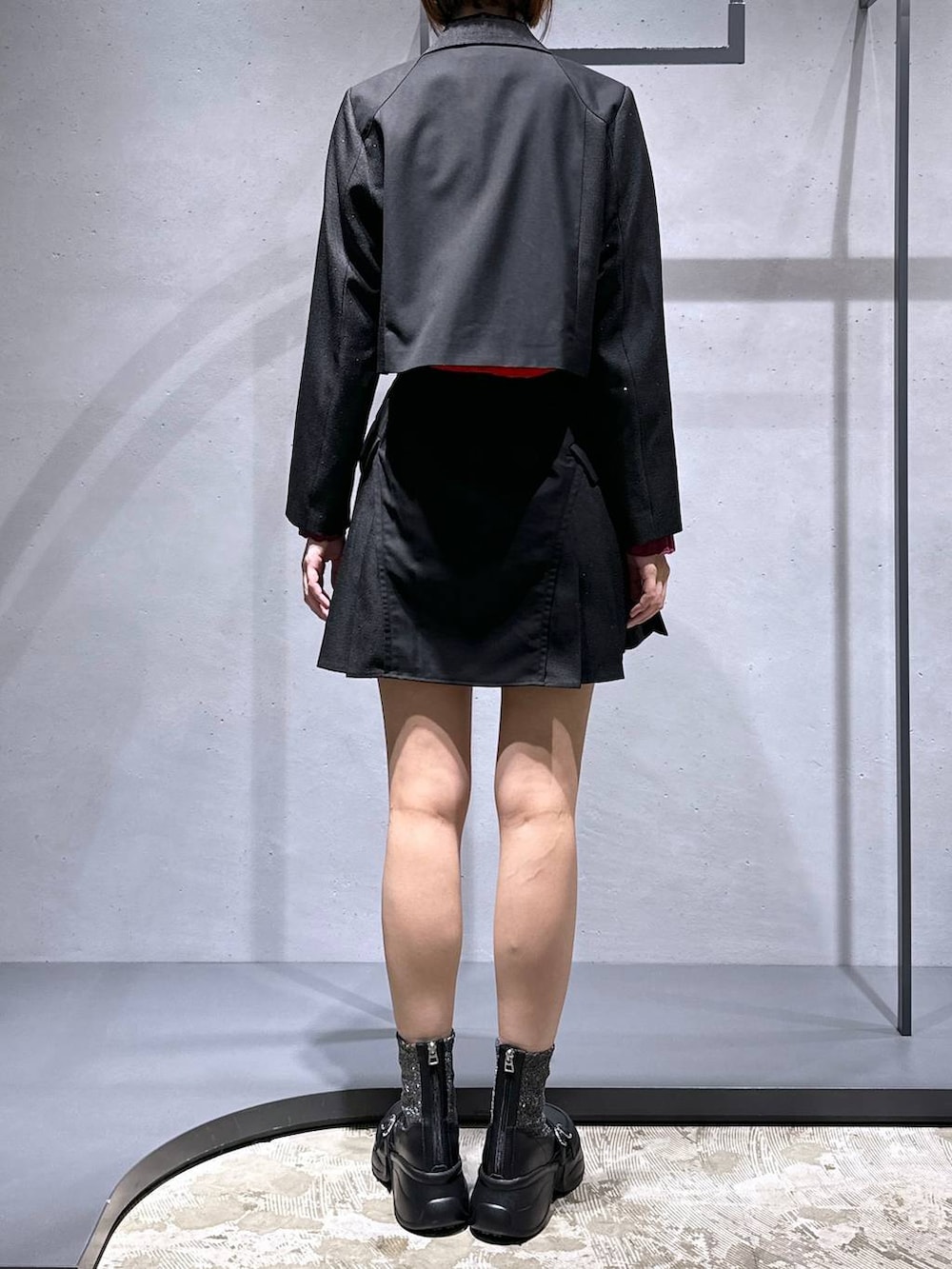 シルバー系のブーツ、ブラック系のテーラードジャケット、ブラック系のその他パンツを着用したレディースの秋コーディネートの3枚目の写真