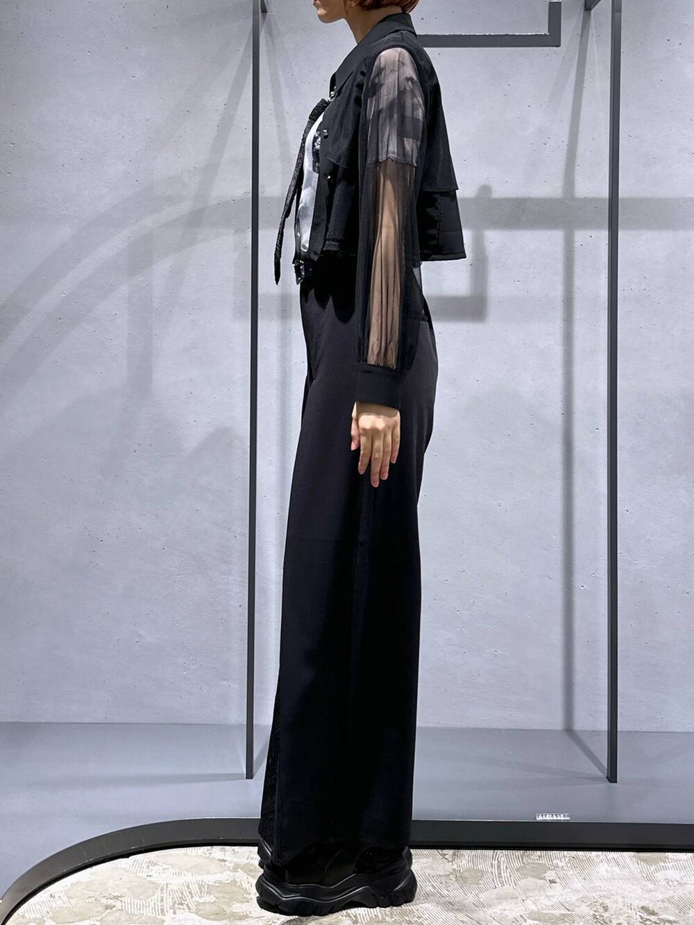 ブラック系のネクタイ、ホワイト系のTシャツ/カットソー、ブラック系のサンダルを着用したレディースの夏コーディネートの2枚目の写真