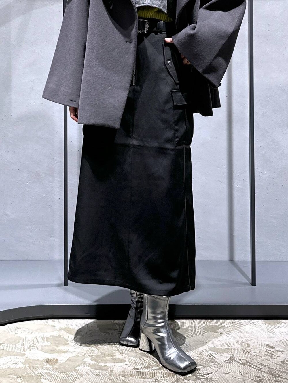 グレー系のチェスターコート、イエロー系のニット/セーター、シルバー系のブーツを着用したレディースの秋コーディネートの7枚目の写真